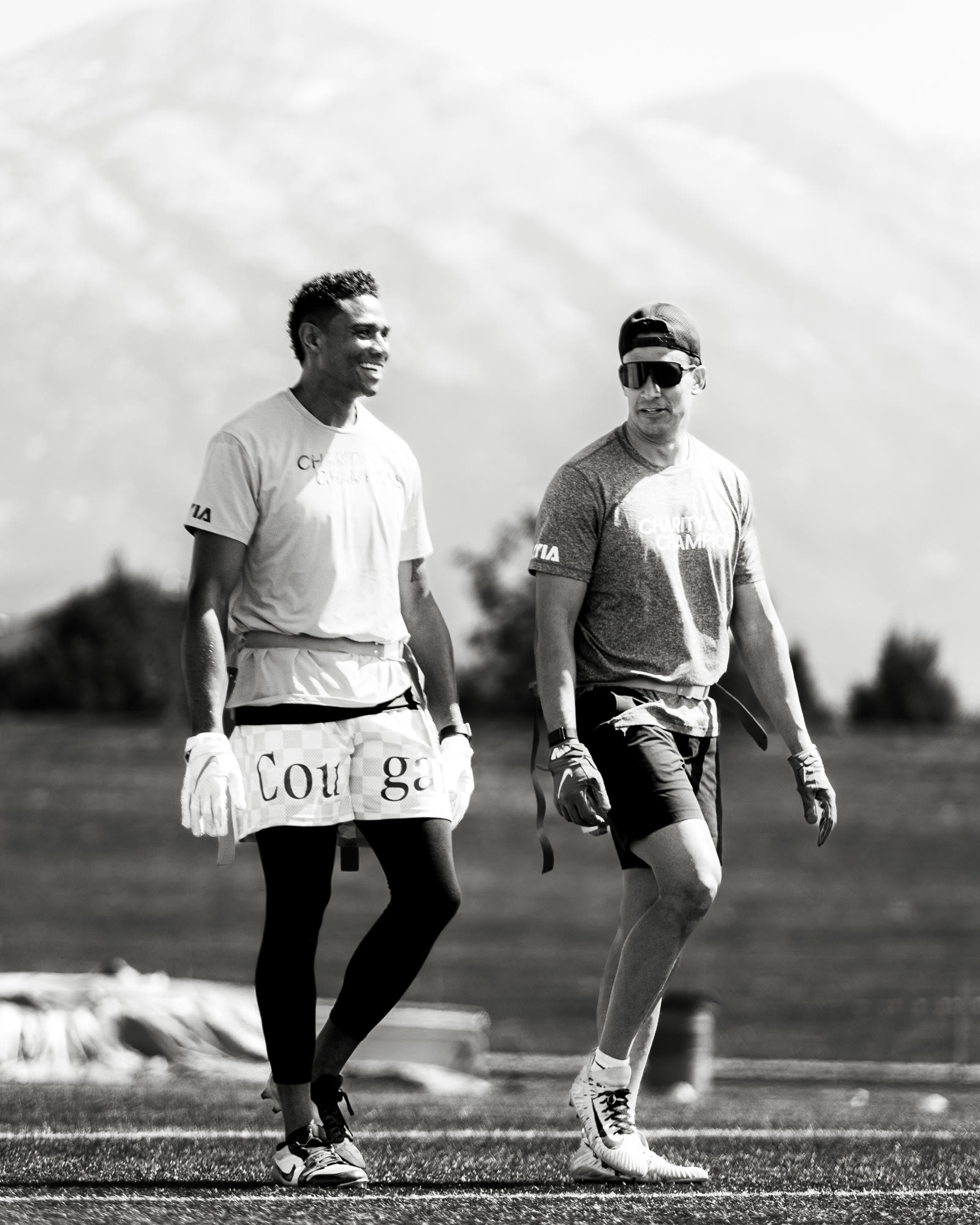Two players walking onto field in black and white